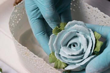 A woman sprinkles homemade zephyr with powdered sugar. Flowers from zephyr. An entrepreneur at...