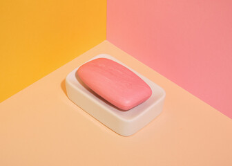 Pink natural soap on a soap dish. Hygienic shower supplies.
