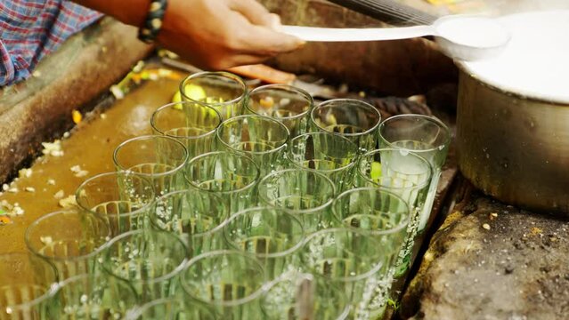 Indian Man Pouring Milk in Glass for Tea