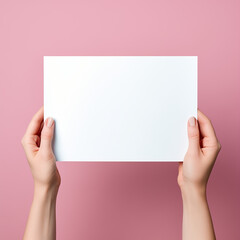 Obraz premium female hands holding blank paper on pink background