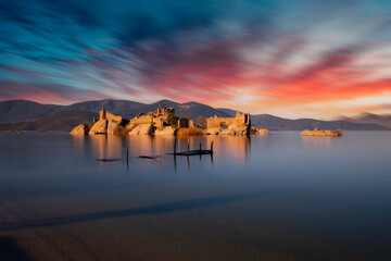 Different views of Bafa Lake in Aegean province of Turkey, boats pier island with monastery and rock forms on a colorful sunset and reflections