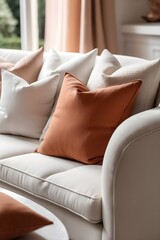 Fototapeta na wymiar Close-up of terracotta and white pillows on a fabric sofa. Interior design for a modern living room in a French country house.