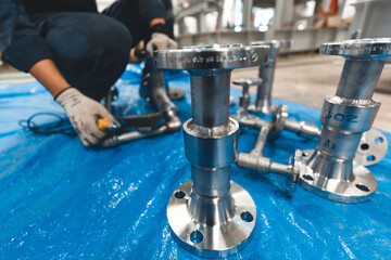 A man starts using a weld hardness the stainless steel piping flange valve component