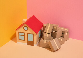 Moving to a new home. House and cardboard packed boxes.