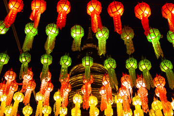 Illuminated colorful lanterns at night on dark sky at Wat Haripunchai during Loy Krathong festival....