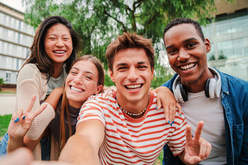 Group of multiracial young academic students smiling and taking a selfie together. Classmates looking at camera at university campus. Close up portrait of happy teenagers laughing and having fun. High - obrazy, fototapety, plakaty