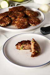 Beef, zucchini and cheddar cheese patties or cutlets on white plate. Dinner meat concept, full of proteins. 
