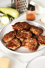 Beef, zucchini and cheddar cheese patties or cutlets on white plate. Dinner meat concept, full of proteins. 