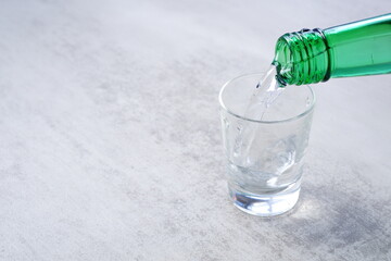 韓国の焼酎（ソジュ）をグラスに注ぐ
