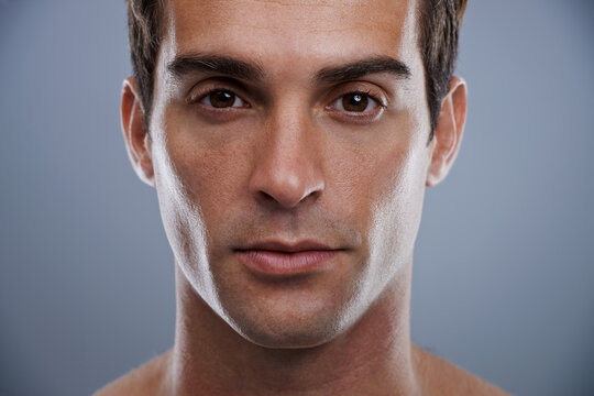 Portrait, skincare and man with dermatology, wellness and confident guy on grey studio background. Face, person and model with beauty and grooming with routine and cosmetics with glow and aesthetic