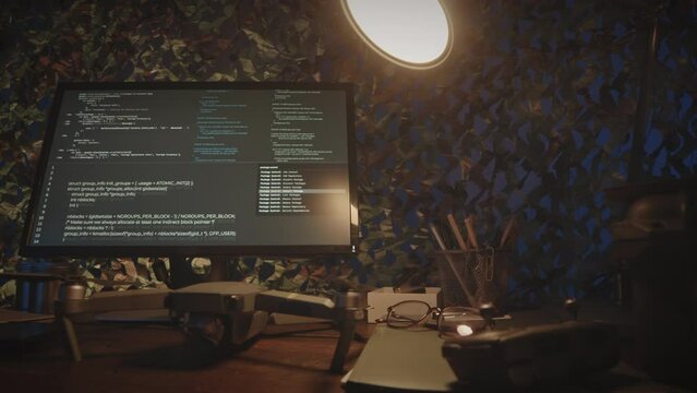 No people low key shot of sophisticated program codes on computer displays at desk in dark military control and surveillance center