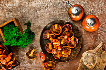 Heap of raw wild saffron milk cap or red pine mushrooms on plate