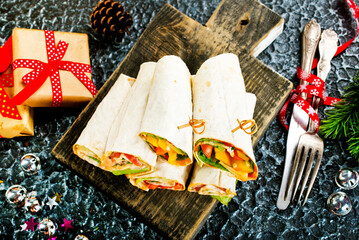Salmon and cream cheese wraps. Rolls with smoked salmon, basil and rocket salad. Burrito on serving board - 720306524
