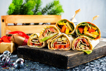 Salmon and cream cheese wraps. Rolls with smoked salmon, basil and rocket salad. Burrito on serving board - 720306577