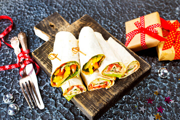 Salmon and cream cheese wraps. Rolls with smoked salmon, basil and rocket salad. Burrito on serving board - 720306580
