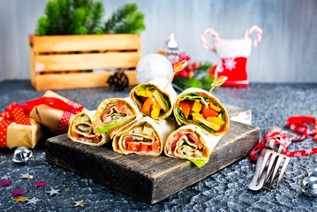 Salmon and cream cheese wraps. Rolls with smoked salmon, basil and rocket salad. Burrito on serving board - 720306581