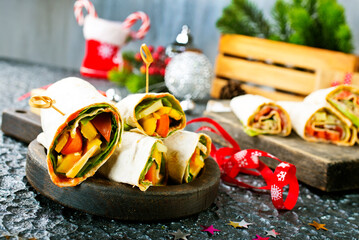 Salmon and cream cheese wraps. Rolls with smoked salmon, basil and rocket salad. Burrito on serving...