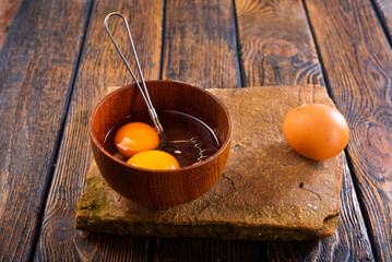 Bowl with raw egg yolk on wooden table, closeup - 720307767