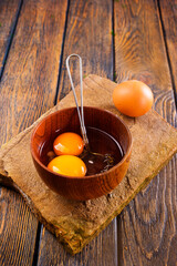 Bowl with raw egg yolk on wooden table, closeup - 720307775