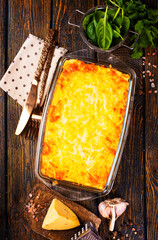 Rectangular glass bowl filled with mashed potato, underneath which is fish in cheese sauce. - 720308118