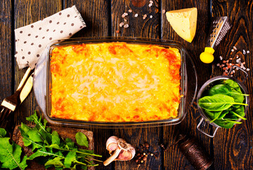 Rectangular glass bowl filled with mashed potato, underneath which is fish in cheese sauce. - 720308193