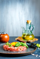 Top view of raw minced meat with liquid egg yolk for preparation of meatball placed on gray plate - 720308933