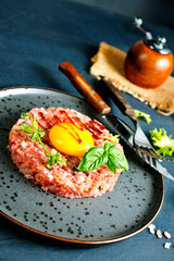 Top view of raw minced meat with liquid egg yolk for preparation of meatball placed on gray plate - 720308939