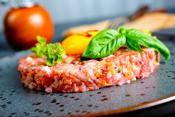 Top view of raw minced meat with liquid egg yolk for preparation of meatball placed on gray plate - 720308944