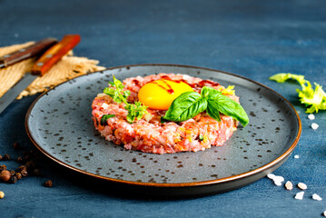 Top view of raw minced meat with liquid egg yolk for preparation of meatball placed on gray plate - 720308950