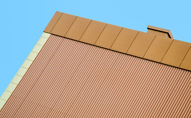 orange wall of a modern building against a blue sky