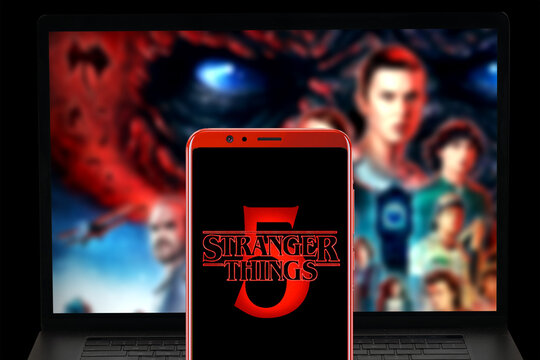 MADURAI, INDIA, 26TH JANUARY 2024: stranger things season 5 logo in mobile screen and series page in Netflix website displayed in laptop blurred background.