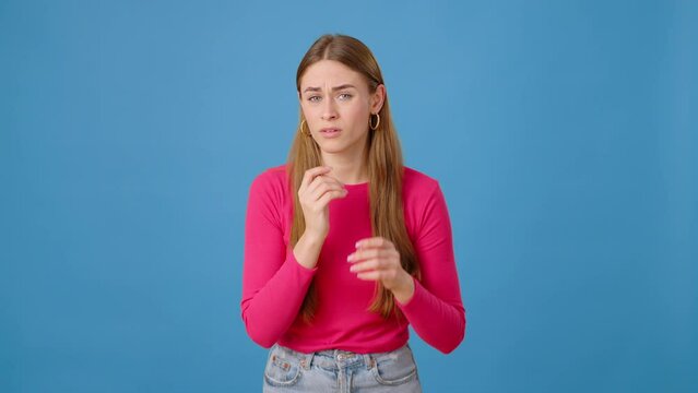 Woman feeling insecure while touching face in blue studio