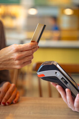 Close-up Hand of a young woman holding a credit card and making a payment transaction.