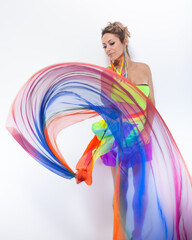 Woman juggling with colorful fabric on a white background