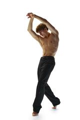 Full length portrait of shirtless young man with athletic body, raising hands and posing in pants...