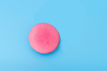 Pink french macaroon or macaron on blue background. Tasty colorful macarons. Cookie made of two...