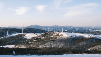 풍력 발전기 주의로 쌓여있는 눈과 넓은 들판