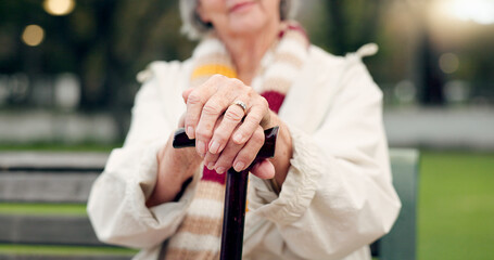 Walking stick, hands and senior woman closeup on a park bench with person with disability. Mobility support, wellness and balance with cane and elderly female person outdoor in a public garden