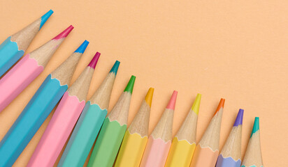 Multi-colored wooden pencils on a beige background