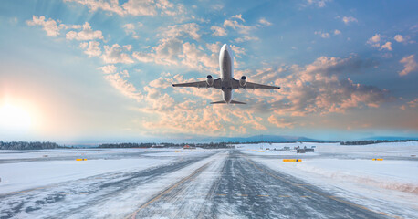 Commercical white airplane fly up over take-off runway the (ice) snow-covered airport- Norway