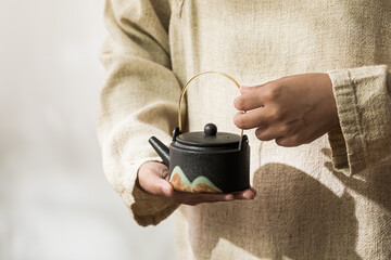 Image of tea set, person making Asian-style tea, tea cup and teapot - obrazy, fototapety, plakaty