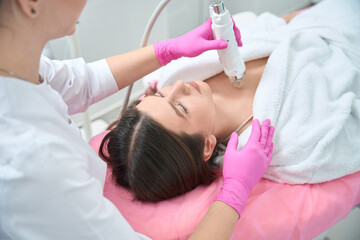 Obraz na płótnie Canvas Beauty procedure, female working with customer in clinic