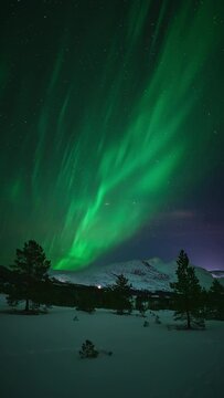 A pulsing aurora lighting up an arctic mountainous landscape in Bod&oslash;.
