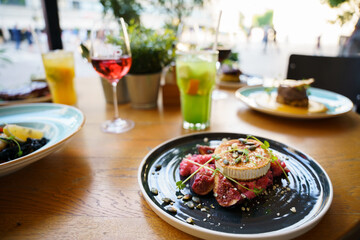 Risotto with beetroot, grilled goat cheese, fig and toasted pumpkin seeds on an outdoor table