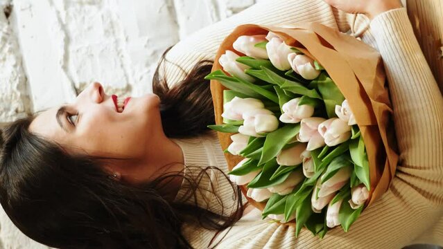 Happy woman drinking coffee and celebrating birthday in coffee shop with bouquet of tulips and bento cake.Birthday concept.Bento cake gift.Vertical video