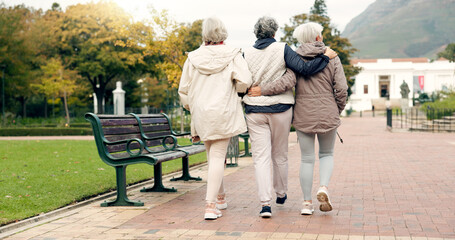Senior friends, talking and walking together on an outdoor path to relax in nature with elderly...