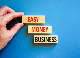 Easy money business symbol. Concept words Easy money business on beautiful wooden blocks. Beautiful blue table blue background. Businessman hand. Easy money business concept. Copy space.