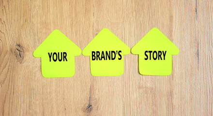 Branding and your brand story symbol. Concept words Your brands story on beautiful yellow paper houses. Beautiful wooden table background. Business branding and your brand story concept. Copy space.