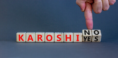 Karoshi yes or no symbol. Concept words Karoshi Yes or No on beautiful wooden blocks. Beautiful grey table grey background. Businessman hand. Business and stop karoshi concept. Copy space.