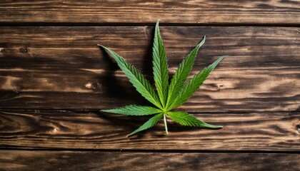 A leaf of marijuana on a wooden table